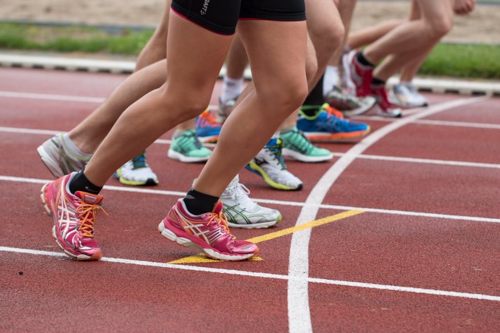 Close-up of athletes' feet at the starting line, prepared for a track race.